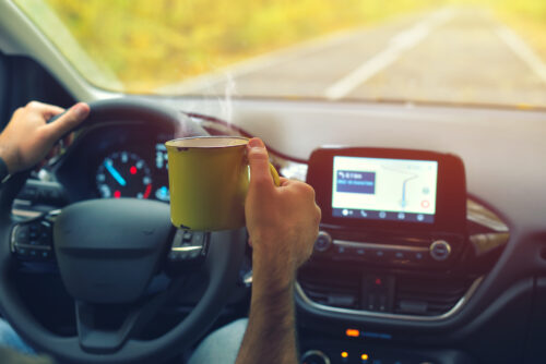 person holding a mug while they are driving distracted driving