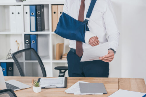 injured worker with broken arm in office