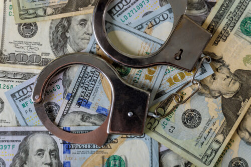 US dollar banknotes money cash corruption, dirty money financial crime of metal police handcuffs