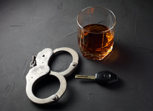 handcuffs alcohol and car keys drunk driving concept